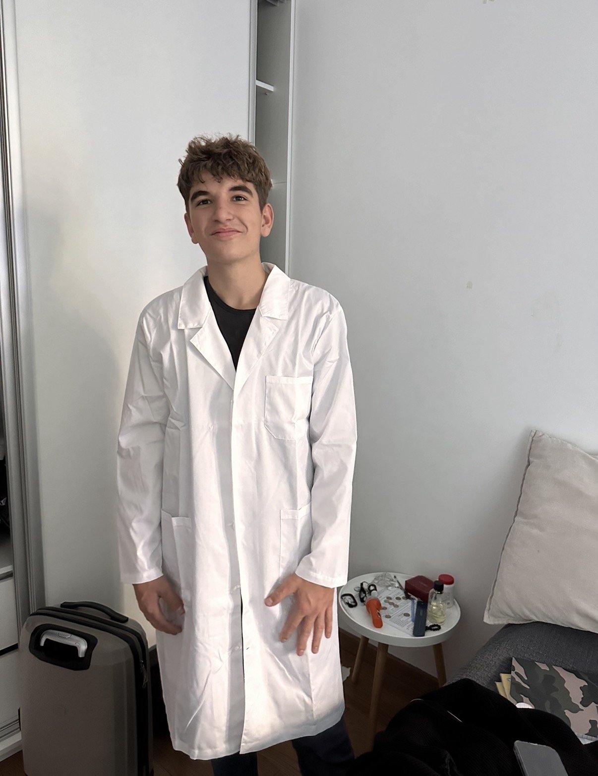 Vladislav at home in a white coat, getting ready for a practical class